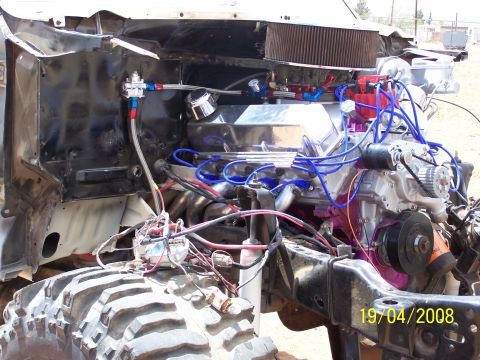 1995 Ford Bronco - The engine bay of a heavily modified off-road vehicle, showing custom fuel lines and engine components.
