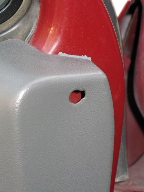 1991 Ford F-150 - Close-up of a vehicle's interior trim panel showing a hole and red painted metal.