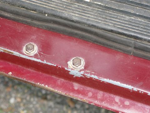 1991 Ford F-150 - Close-up of the door sill on a 1991 Ford F-150, showing two visible bolts.