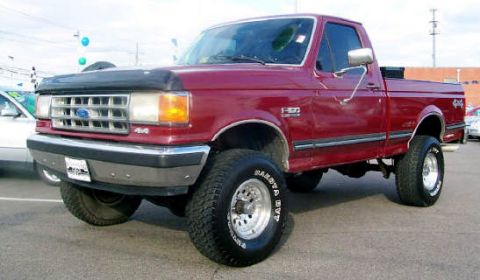1991 Ford F-150 - A maroon 1991 Ford F-150 pickup truck is shown from a three-quarter front angle.
