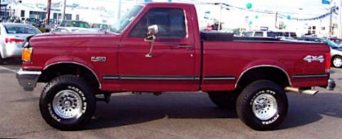 1991 Ford F-150 - This red 1991 Ford F-150 pickup truck is shown in a side profile, its 4x4 capabilities.
