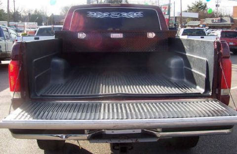 1991 Ford F-150 - The rear view of a pickup truck shows its empty bed and a diamond-plate toolbox.