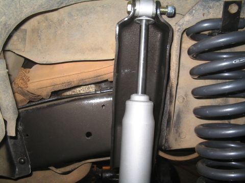 1979 Ford Bronco - Close-up view of a vehicle's suspension system, showing a shock absorber and coil spring.