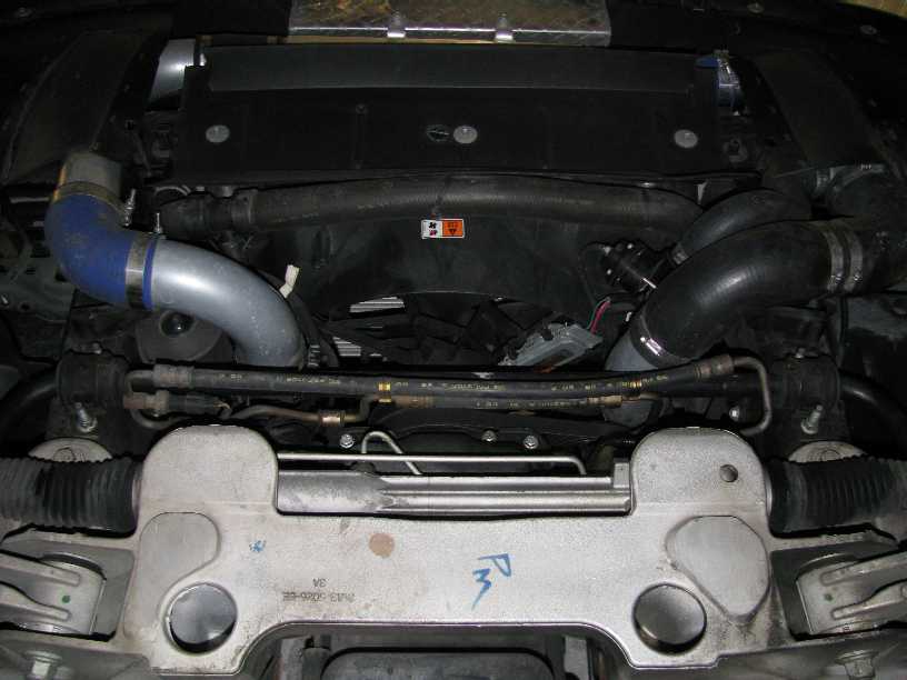Engine bay front view with blue and gray intake hoses and core support markings