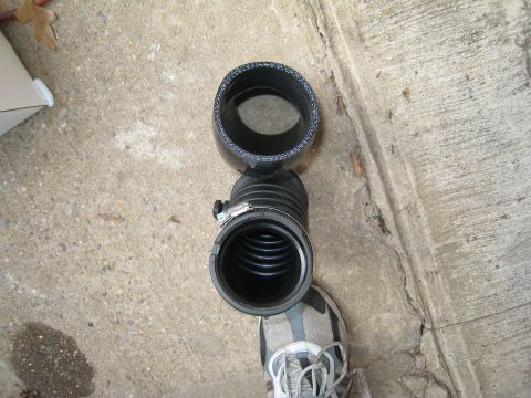 2007 Subaru Impreza - Two black automotive hoses, likely for an engine's air intake system, are laid out on a concrete surface.