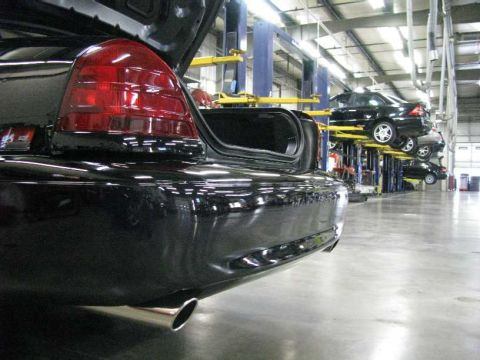 2003 Mercury Marauder - Several cars are parked on lifts inside a brightly lit auto repair shop.