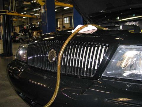 2003 Mercury Marauder - Front view of a black 2003 Mercury Marauder in a service bay with a hose on the grille.