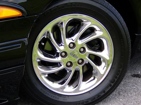 1996 Mercury Grand Marquis - Close-up of a chrome wheel with a Lincoln logo on a black vehicle.