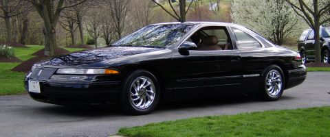 1996 Mercury Grand Marquis - A black coupe with chrome wheels is parked on a driveway, with another dark SUV visible in the background.