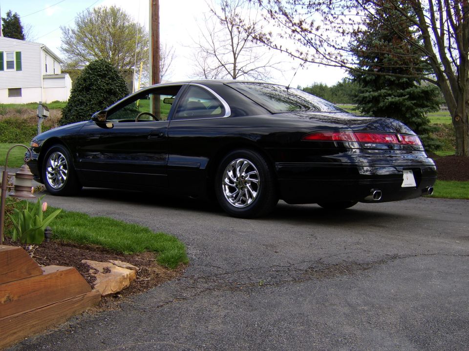 Black Lincoln Mark VIII coupe, rear three-quarter, full-width tail-light bar