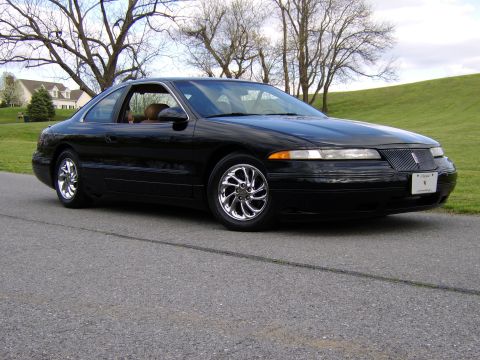 1996 Mercury Grand Marquis - This black coupe has a distinctive grille and chrome wheels, with a tan interior visible through the window.
