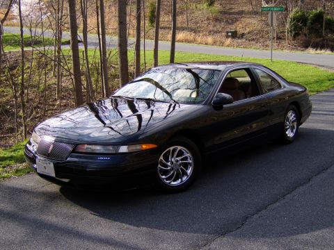 1996 Mercury Grand Marquis - A black Lincoln Mark VIII coupe is parked on a residential street with trees and a road sign visible.