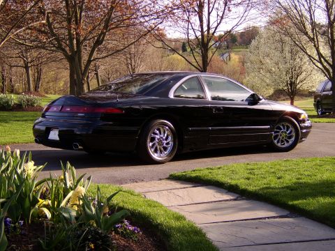 1996 Mercury Grand Marquis - Black coupe with chrome wheels parked on a driveway during daytime.