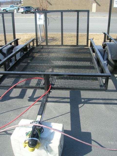 2003 Jeep TJ - A utility trailer is shown from a front-facing perspective, with a price tag visible on a post behind it.