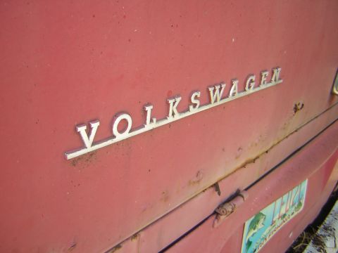 1971 Volkswagen Vanagon - The VOLKSWAGEN emblem is visible on the red body of a vehicle, with a license plate in the background.