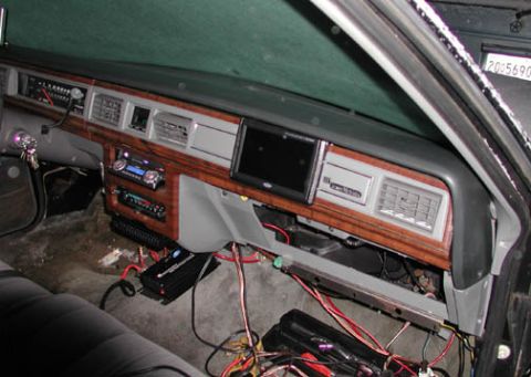 1988 Ford LTD Crown Victoria - Interior shot across the dashboard of a 1980s Ford sedan mid-install, showing the woodgrain trim, gray vinyl dash pad and factory HVAC vent…