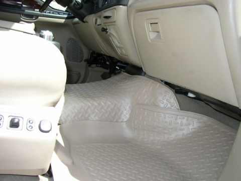 1995 Ford Bronco - The interior of the vehicle shows tan upholstery and heavy-duty floor mats covering the passenger side.
