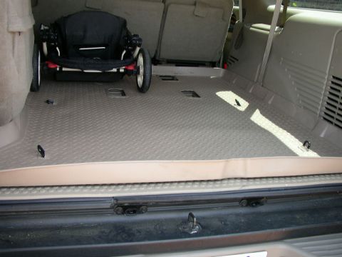 1995 Ford Bronco - The interior of an SUV's cargo area is shown, with a stroller placed on the floor.