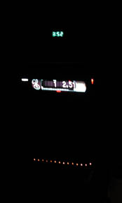 1988 Ford LTD Crown Victoria - Dark night interior shot of a car dash showing an aftermarket head unit's lit display reading 12.51 with green level bars, a small green di…