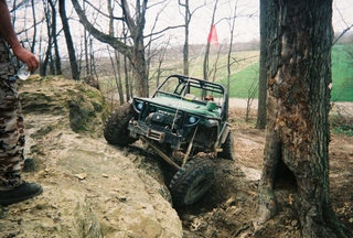 1992 Ford Bronco - An off-road vehicle tackles a challenging rocky terrain, with the SuperMotors logo present in the lower right corner.