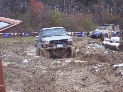 1990 Ford Ranger - A modified Ford pickup truck navigates a muddy obstacle course with another vehicle in the background.