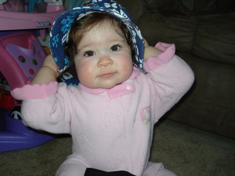 2000 Ford Crown Victoria - A baby wearing pink pajamas and a blue sun hat is looking at the camera.