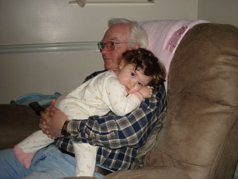 2000 Ford Crown Victoria - A grandfather holds a baby, both looking towards the camera. The baby is in his arms.