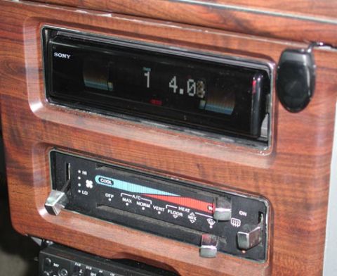 1988 Ford LTD Crown Victoria - Close-up of a Sony aftermarket head unit installed in a woodgrain center stack, its display reading 14.00, mounted directly above the facto…
