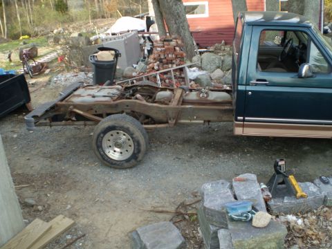 1995 Ford F-150 - The chassis and cab of a 1995 Ford F-150 are visible, with the rear section removed and the truck appearing to be under repair.
