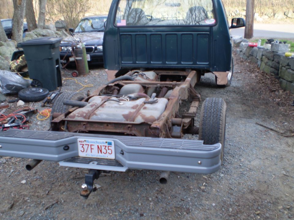 1995 Ford F-150 chassis with fuel tank and rear bumper; another car is visible in the background