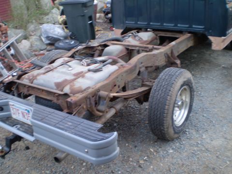 1995 Ford F-150 - The rear chassis of a truck, showing dual fuel tanks and leaf spring suspension, with a gray bumper.