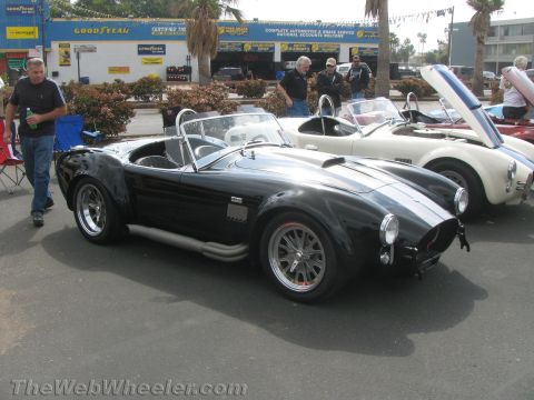 1968 Ford Mustang - Two AC Cobra sports cars parked side-by-side at an outdoor car show.