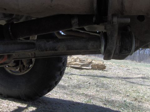 1992 Ford F-350 - Close-up of a truck's undercarriage, focusing on suspension parts and a large tire.