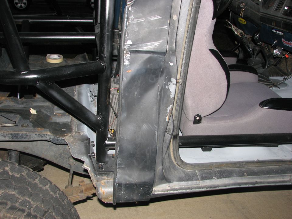 Modified vehicle interior showing roll cage, racing seat, and door frame