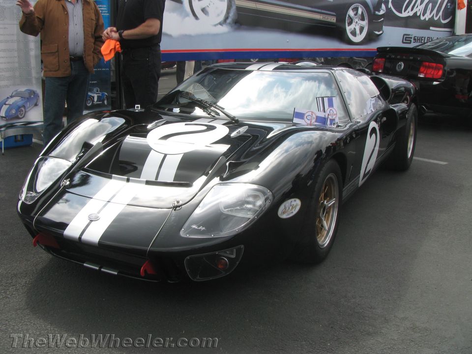 Black race car with white stripes and number 2, gold wheels