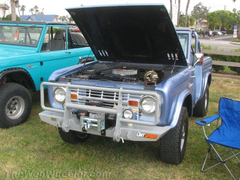1968 Ford Mustang - A blue 1966 Ford Bronco is shown with its hood open, revealing the engine, alongside another blue Bronco.