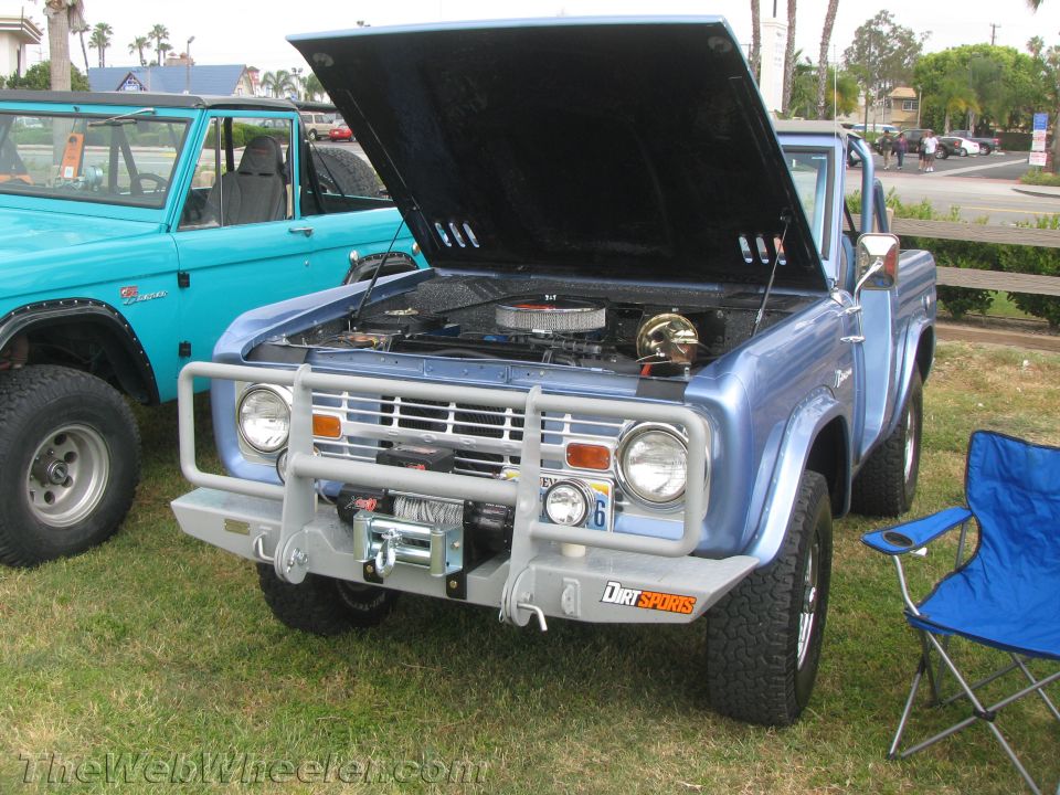 Blue 1966 Ford Bronco with hood open, winch, and "Dirt Sports" decal