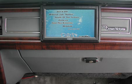 1988 Ford LTD Crown Victoria - Interior dashboard shot of a Ford LTD Crown Victoria showing an aftermarket in-dash LCD screen displaying a list of song titles over a blue…