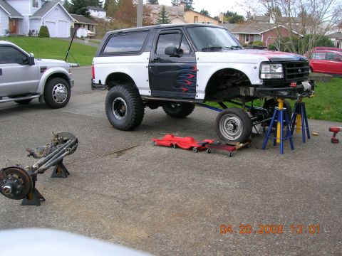 1996 Ford Bronco - Ford Bronco undergoing repairs, with front end disassembled and supported by jack stands.