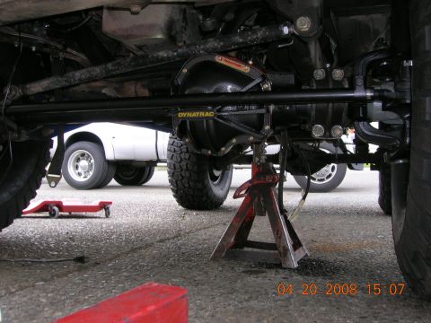 1996 Ford Bronco - The photo shows the undercarriage of a vehicle, focusing on the differential and suspension parts, with another truck in the background.