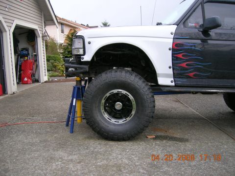 1996 Ford Bronco - This lifted truck, flame decals, is shown on jack stands in a driveway.