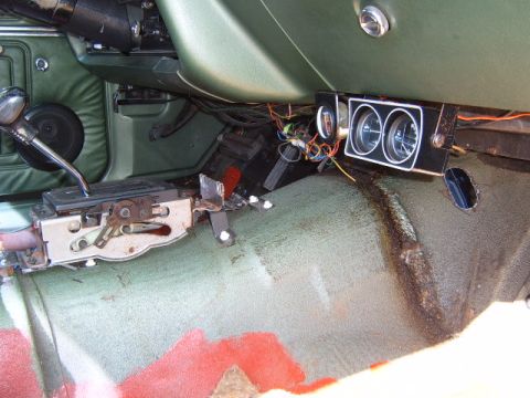 1973 Ford Ranchero - The interior of a 1973 Ford Ranchero features an automatic transmission shifter and dashboard gauges, with visible wiring and wear.