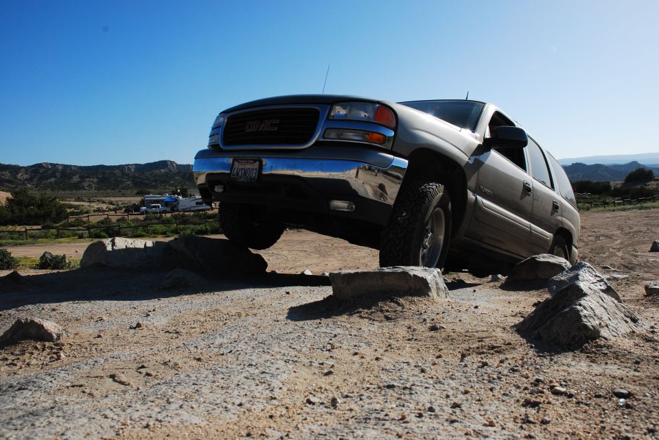 GMC Yukon XL driving over rocks off-road