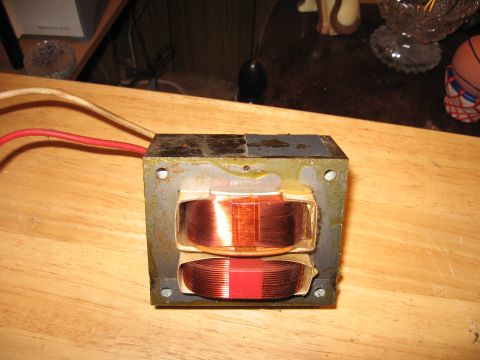 1992 Ford Crown Victoria - A transformer with visible copper coils and attached red and white wires sits on a wooden surface.