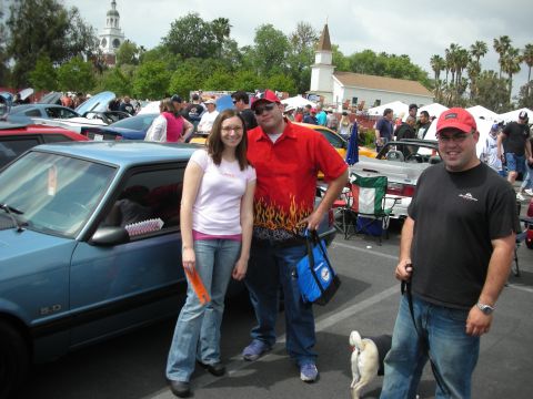 1992 Ford Crown Victoria - A blue Ford Mustang is parked at an outdoor car show with people standing next to it.