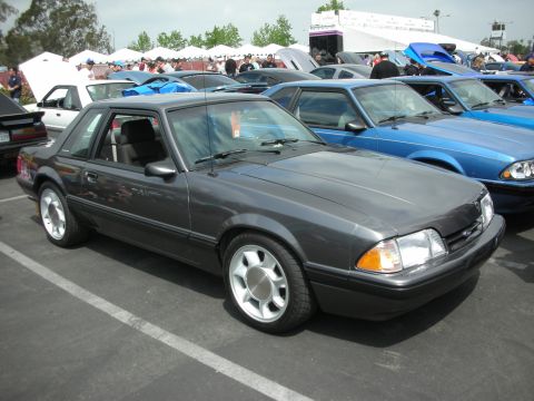 1992 Ford Crown Victoria - A dark gray coupe with a black interior is parked at an outdoor car show, with other vehicles visible in the background.