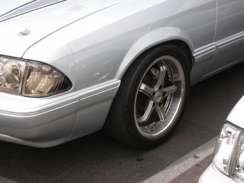 1992 Ford Crown Victoria - A silver sedan with custom wheels is parked next to another vehicle.