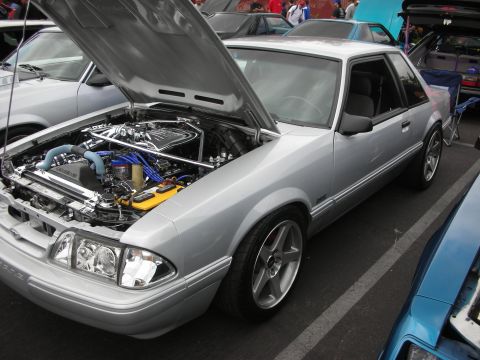 1992 Ford Crown Victoria - A silver 1992 Ford Mustang GT is displayed with its hood open, revealing the engine bay.