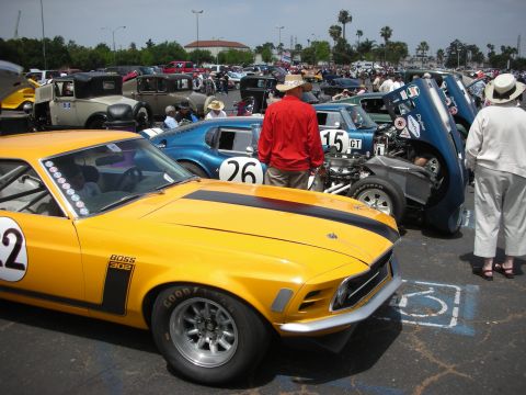 1992 Ford Crown Victoria - A bright yellow 1970 Ford Mustang Boss 302 is parked at a car show, with other classic cars visible in the background.