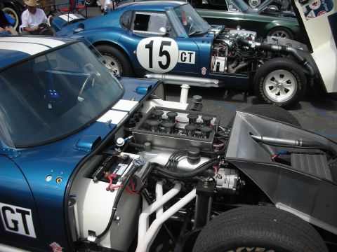 1992 Ford Crown Victoria - Two blue race cars are parked side-by-side, one with its hood open revealing the engine.